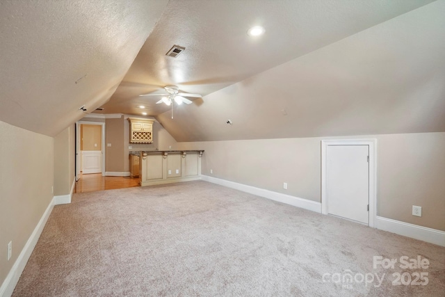100 Woodwinds Dr, Mount Holly, NC 28120 - bonus room featuring light colored carpet, ceiling fan, vaulted ceiling, baseboards, and a textured ceiling