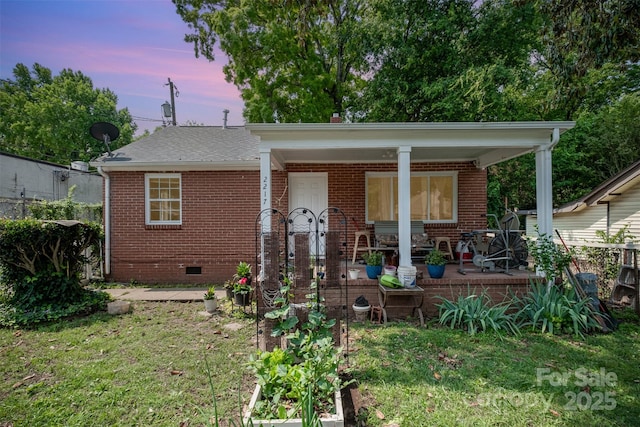 2217 Tate St, Charlotte, NC 28216 - bungalow-style house featuring brick siding, crawl space, covered porch, and a lawn