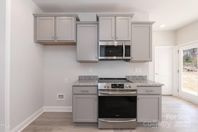 236 Mountain Island Rd Unit 40, Statesville, NC 28677 - kitchen featuring appliances with stainless steel finishes, gray cabinets, light wood-type flooring, baseboards, and light stone counters