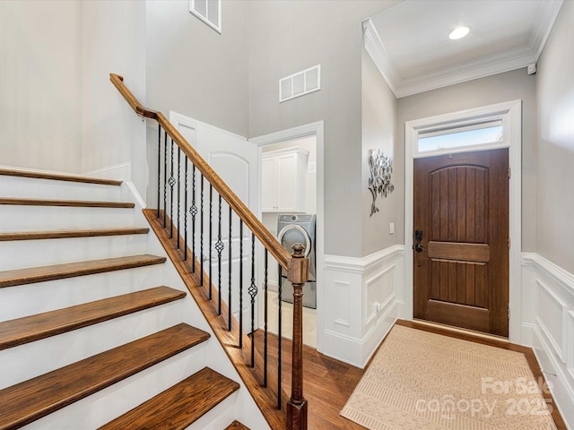 5030 Waldron Meadow Dr, Charlotte, NC 28226 - foyer with crown molding, washer / dryer, dark wood-style flooring, a wainscoted wall, and stairway