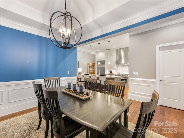 5030 Waldron Meadow Dr, Charlotte, NC 28226 - dining area featuring a chandelier, light wood-type flooring, ornamental molding, a decorative wall, and wainscoting