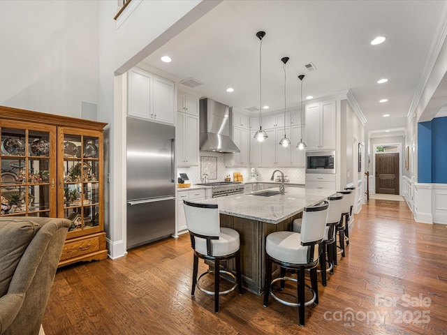 5030 Waldron Meadow Dr, Charlotte, NC 28226 - kitchen featuring built in appliances, wall chimney range hood, a sink, a breakfast bar area, and white cabinetry