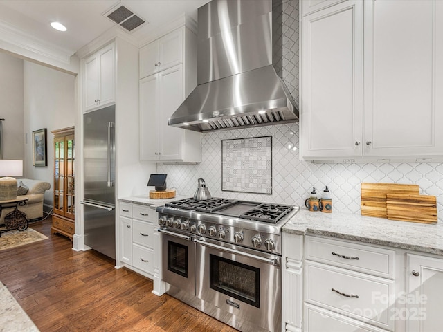 5030 Waldron Meadow Dr, Charlotte, NC 28226 - kitchen with premium appliances, wall chimney exhaust hood, backsplash, white cabinetry, and recessed lighting