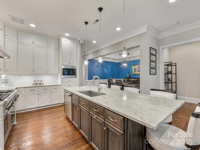 5030 Waldron Meadow Dr, Charlotte, NC 28226 - kitchen with a sink, a kitchen breakfast bar, appliances with stainless steel finishes, white cabinets, and crown molding
