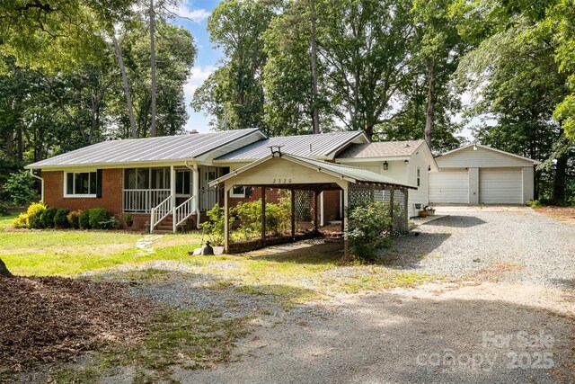 2320 Doster Rd, Monroe, NC 28112 - single story home with an outbuilding, brick siding, a detached garage, and metal roof
