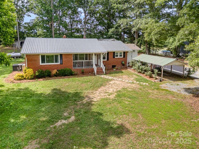 2320 Doster Rd, Monroe, NC 28112 - single story home featuring brick siding, a front yard, metal roof, and driveway