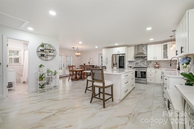 2320 Doster Rd, Monroe, NC 28112 - kitchen with wall chimney range hood, stainless steel appliances, a sink, a kitchen breakfast bar, and light countertops