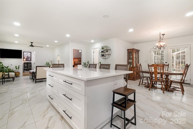 2320 Doster Rd, Monroe, NC 28112 - kitchen with a breakfast bar area, recessed lighting, light marble finish floors, a ceiling fan, and white cabinetry