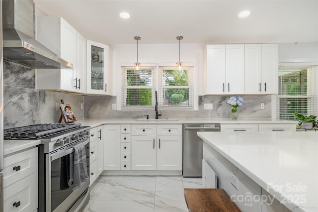 2320 Doster Rd, Monroe, NC 28112 - kitchen featuring wall chimney range hood, appliances with stainless steel finishes, a sink, light marble finish flooring, and white cabinetry