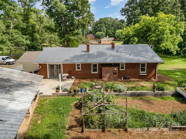 2320 Doster Rd, Monroe, NC 28112 - rear view of house with a patio area, brick siding, a chimney, french doors, and metal roof