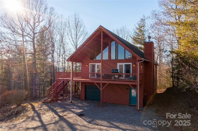 693 Blackberry Ridge Rd, Burnsville, NC 28714 - back of property featuring stairs, a wooden deck, a chimney, gravel driveway, and log veneer siding