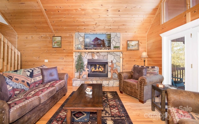 693 Blackberry Ridge Rd, Burnsville, NC 28714 - living room with lofted ceiling, wood finished floors, a stone fireplace, wood walls, and wood ceiling