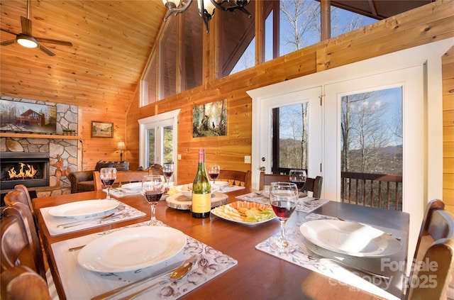 693 Blackberry Ridge Rd, Burnsville, NC 28714 - dining space featuring wood ceiling, wood walls, wood finished floors, a stone fireplace, and high vaulted ceiling