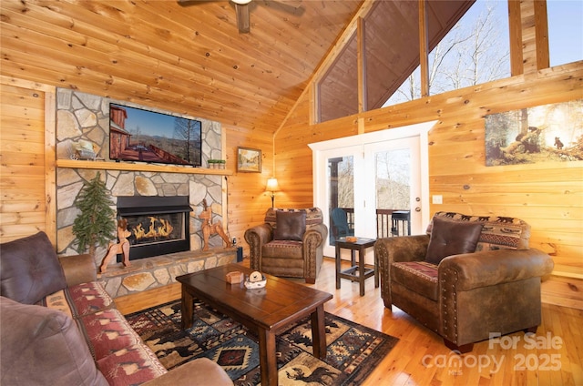693 Blackberry Ridge Rd, Burnsville, NC 28714 - living area featuring wood walls, a stone fireplace, wood finished floors, wooden ceiling, and a ceiling fan