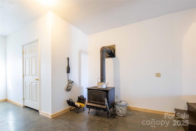 693 Blackberry Ridge Rd, Burnsville, NC 28714 - living room with finished concrete floors, a wood stove, and baseboards