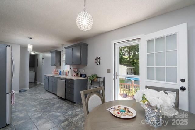 103 Poplar Trl, Rockwell, NC 28138 - kitchen featuring stainless steel appliances, gray cabinets, washer / dryer, a chandelier, and a textured ceiling