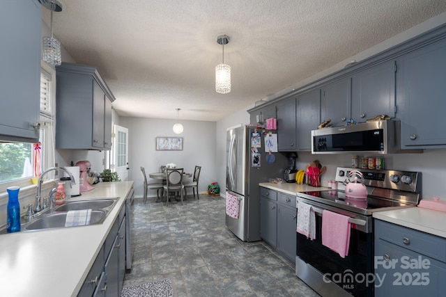 103 Poplar Trl, Rockwell, NC 28138 - kitchen with stainless steel appliances, a sink, light countertops, pendant lighting, and a textured ceiling