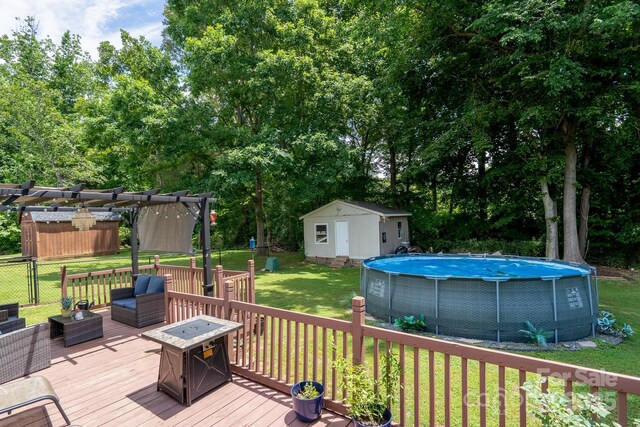 103 Poplar Trl, Rockwell, NC 28138 - wooden deck with an outdoor pool, a lawn, a pergola, and view of wooded area