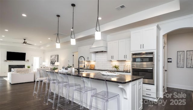 411 Newstyle Way, Gastonia, NC 28056 - kitchen featuring double oven, dark countertops, a tray ceiling, arched walkways, and recessed lighting