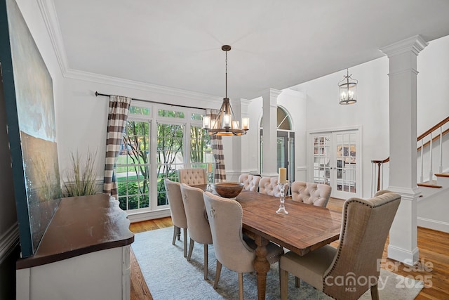 3506 Cardiff Ln, Matthews, NC 28104 - dining room featuring a chandelier, ornate columns, stairway, wood finished floors, and crown molding