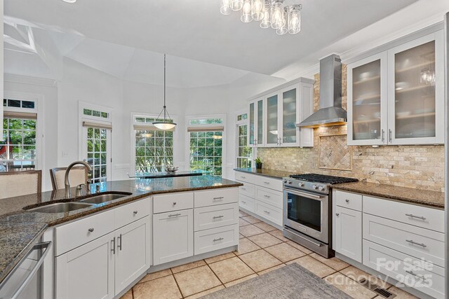 3506 Cardiff Ln, Matthews, NC 28104 - kitchen featuring appliances with stainless steel finishes, wall chimney range hood, healthy amount of natural light, and decorative backsplash