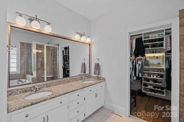 3506 Cardiff Ln, Matthews, NC 28104 - full bath featuring a spacious closet, double vanity, a stall shower, tile patterned floors, and a garden tub