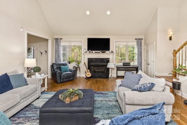 33 Stone House Rd, Arden, NC 28704 - living area with high vaulted ceiling, plenty of natural light, a fireplace with raised hearth, wood finished floors, and stairs