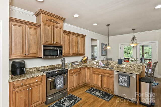 33 Stone House Rd, Arden, NC 28704 - kitchen featuring stainless steel appliances, a sink, a peninsula, wood finished floors, and brown cabinetry