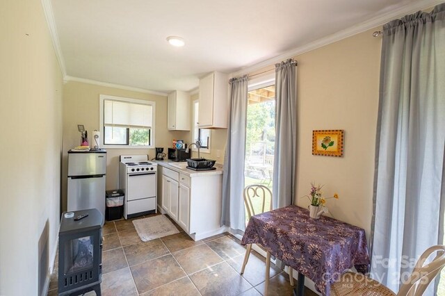 5430 Ela Rd, Whittier, NC 28789 - kitchen with white range with electric cooktop, ornamental molding, white cabinetry, freestanding refrigerator, and light countertops