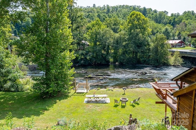5430 Ela Rd, Whittier, NC 28789 - view of grassy yard featuring an outdoor fire pit, a deck with water view, and a wooded view