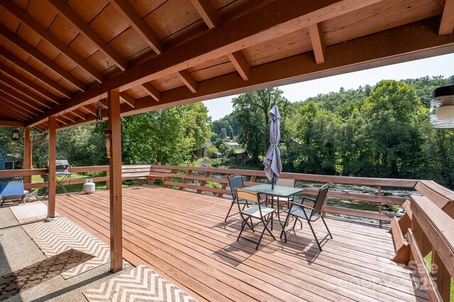 5430 Ela Rd, Whittier, NC 28789 - wooden deck featuring outdoor dining area and view of scattered trees