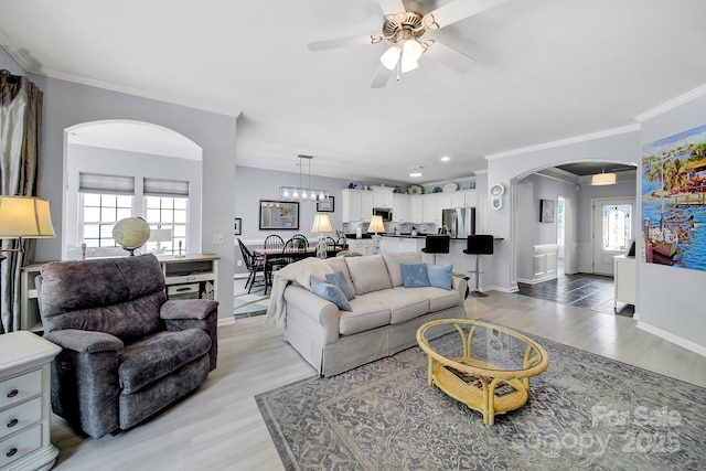 2224 Hartwell Ln, Fort Mill, SC 29707 - living room with arched walkways, a ceiling fan, light wood finished floors, baseboards, and ornamental molding