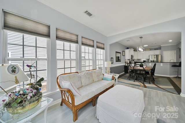 2224 Hartwell Ln, Fort Mill, SC 29707 - living area featuring light wood-style flooring, baseboards, arched walkways, and a chandelier