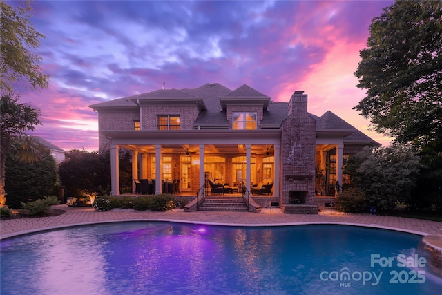 1509 Churchill Downs Dr, Waxhaw, NC 28173 - back of house with a ceiling fan, an outdoor brick fireplace, a patio, a chimney, and an outdoor pool