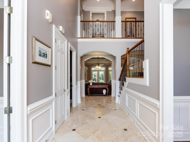 1509 Churchill Downs Dr, Waxhaw, NC 28173 - entryway featuring a decorative wall, wainscoting, arched walkways, stairway, and ceiling fan