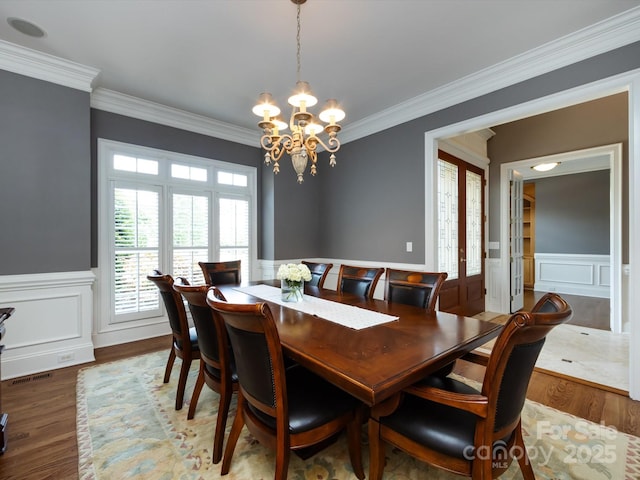 1509 Churchill Downs Dr, Waxhaw, NC 28173 - dining space featuring crown molding, a chandelier, wainscoting, wood finished floors, and a decorative wall
