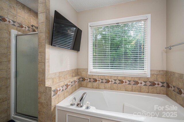 107 Ingonish Dr, Gastonia, NC 28056 - full bathroom with healthy amount of natural light, a shower stall, a garden tub, and a textured ceiling