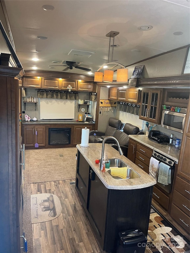 5400 Little River Neck Rd Unit 169, North Myrtle Beach, SC 29582 - kitchen with an island with sink, dark wood-style floors, a sink, and light stone counters