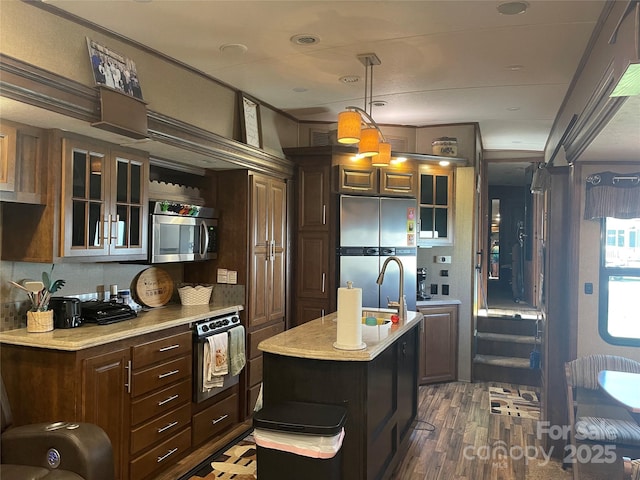 5400 Little River Neck Rd Unit 169, North Myrtle Beach, SC 29582 - kitchen featuring appliances with stainless steel finishes, light countertops, glass insert cabinets, dark wood finished floors, and a kitchen island with sink