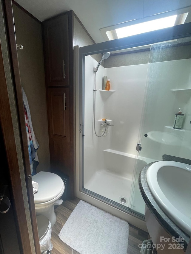 5400 Little River Neck Rd Unit 169, North Myrtle Beach, SC 29582 - bathroom with a shower stall, toilet, a sink, and wood finished floors