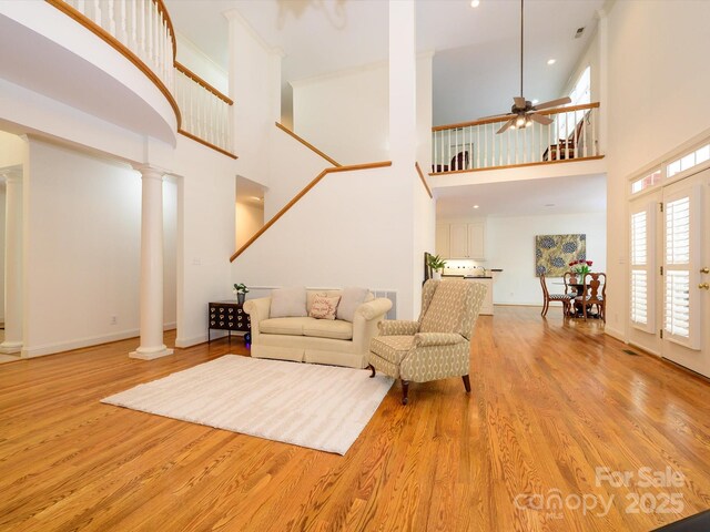 1209 S S St, Gastonia, NC 28052 - living area with ornate columns, a towering ceiling, light wood-type flooring, ceiling fan, and baseboards