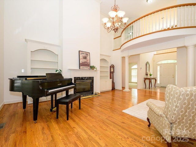 1209 S S St, Gastonia, NC 28052 - sitting room featuring built in shelves, a towering ceiling, light wood-style flooring, and a chandelier