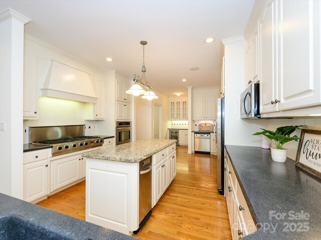 1209 S S St, Gastonia, NC 28052 - kitchen with custom range hood, appliances with stainless steel finishes, white cabinets, tasteful backsplash, and light wood-style floors
