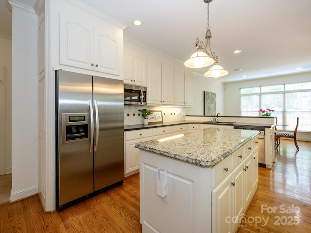 1209 S S St, Gastonia, NC 28052 - kitchen featuring stainless steel appliances, a sink, a peninsula, light wood-style flooring, and a center island