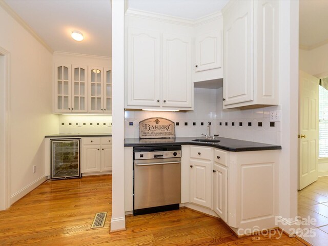 1209 S S St, Gastonia, NC 28052 - kitchen featuring wine cooler, stainless steel dishwasher, dark countertops, white cabinets, and ornamental molding