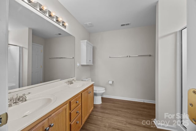 423 Courtland Ct, Kannapolis, NC 28081 - bathroom featuring double vanity, wood finished floors, baseboards, toilet, and an enclosed shower