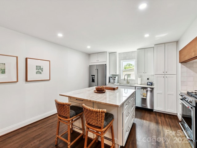 1638 Wensley Dr, Charlotte, NC 28210 - kitchen with high quality appliances, a sink, backsplash, a kitchen breakfast bar, and dark wood finished floors