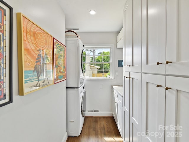 1638 Wensley Dr, Charlotte, NC 28210 - washroom featuring cabinet space, stacked washer and clothes dryer, baseboards, dark wood-type flooring, and recessed lighting