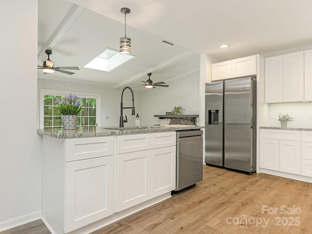 406 Wilcrest Dr, Matthews, NC 28105 - kitchen featuring stainless steel appliances, a ceiling fan, a sink, a skylight, and vaulted ceiling