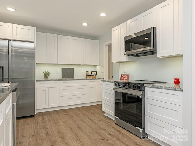 406 Wilcrest Dr, Matthews, NC 28105 - kitchen featuring stainless steel appliances, recessed lighting, light wood finished floors, white cabinets, and light stone countertops